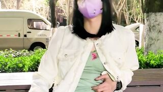 Oriental ladyboy cums in a park with pedestrians