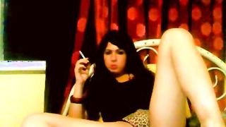 Exciting brunette transsexual smokes and poses naked in the bed